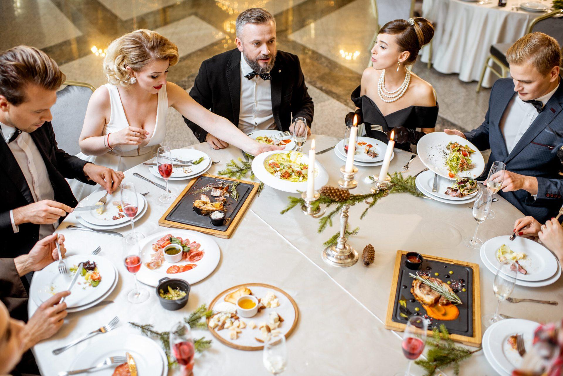 Festlich gedeckte Tafel mit Gästen im Abendlicht